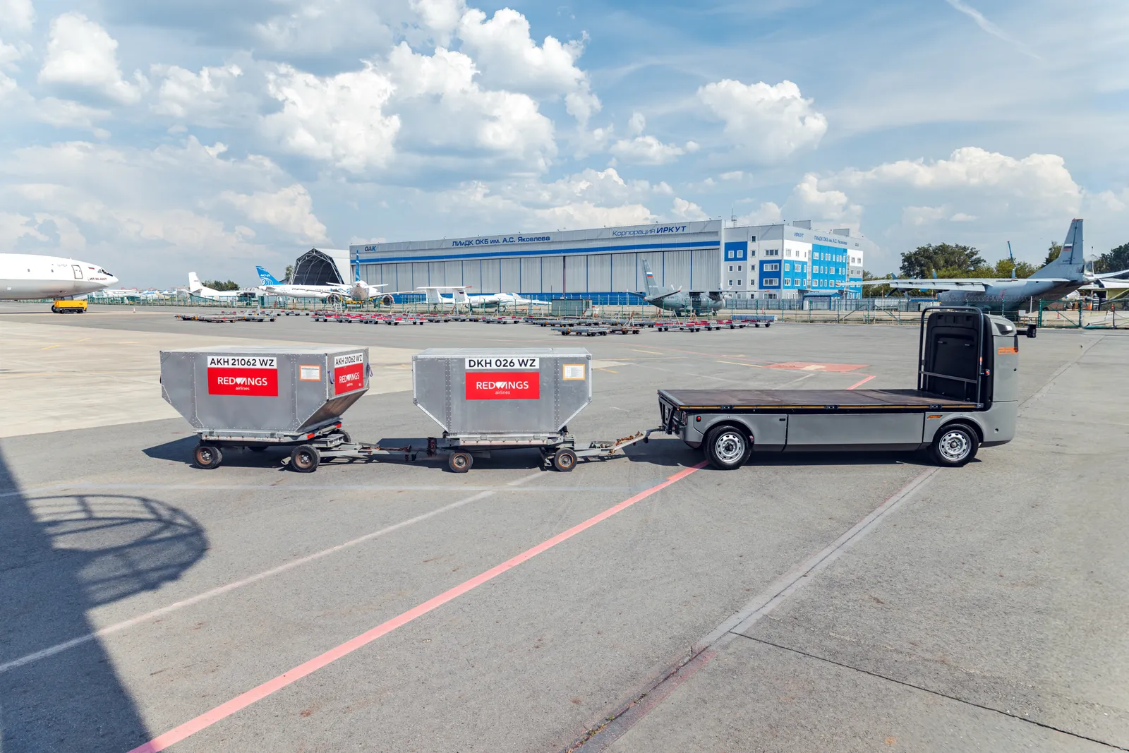 Беспилотная электроплатформа Evocargo с багажными тележками Red Wings на перроне аэропорта Жуковский